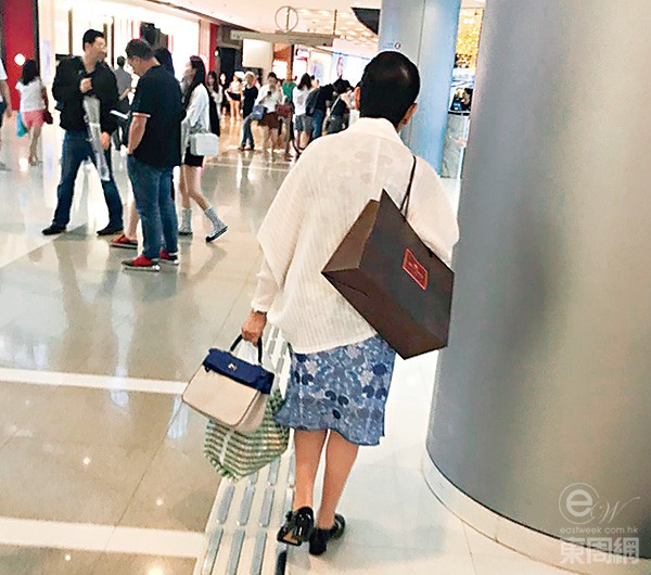 膊头孭住名店大纸袋嘅星妈,似系啱啱「血拼」完.